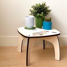 Low side table with a minimalist, modern design featuring a light-colored wooden top and black metal legs. Suitable for use as an end table or nightstand in a variety of interior styles.