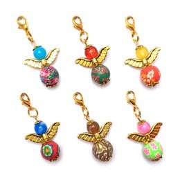 Set of 6 gold-colored guardian angel "Flora" keyrings with colorful gemstone accents. Decorative charms feature a hummingbird design with a red gemstone body.