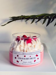 Strawberry Dream scented candle with red strawberry pieces and a white label.