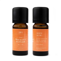 Two amber glass bottles with black caps, containing a white musk fragrance oil. The bottles are labeled "No 2 Dubai White Musk | Limited Edition" and "Fragrance Supply".