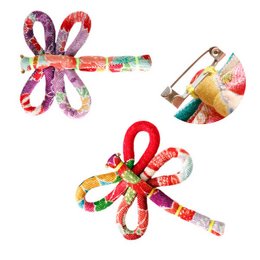 Accessory brooch made of colorful kimono fabric in the shape of a dragonfly. Features intricate patterns and vibrant colors.