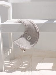 Gray fabric bib with textured pattern and snap closure.