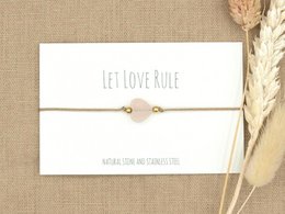 A delicate rose quartz bracelet with a gold or silver stainless steel charm, perfect for adding a touch of elegance to any outfit.