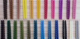 Handmade beeswax taper candles in a variety of twisted, spiral, and minimalist designs and colors suitable for modern dinner table decor.