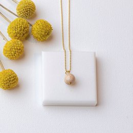 Gold chain with a small pendant, featuring a delicate heart-shaped charm.