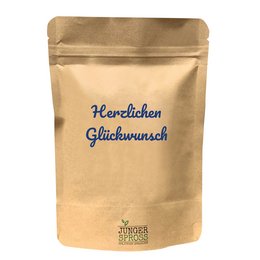 A round, tall yellow candle with the text "Herzlichen Glückwunsch" (Congratulations) printed on the packaging.