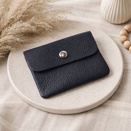  Compact dark blue leather wallet with snap closure and zipper compartment for coins.