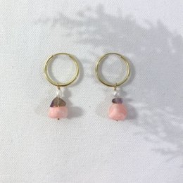 Gold hoop earrings with pink stone pendants. Elegant and feminine style.