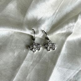 Silver cow-shaped charm hoop earrings with intricate detailing.