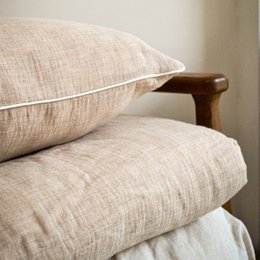  Beige linen duvet cover with wooden accents, suitable for a cozy bedroom.