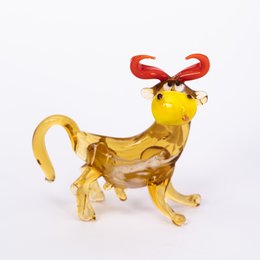 Glass animal in the shape of a cow with red horns and accents.