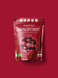 Dried cherries in a package and bowl, with a wooden surface. The cherries are deep red in color and appear to be crunchy and sweet.