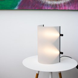  A modern, minimalist table lamp with a frosty white cylindrical shade and a simple, sleek design.