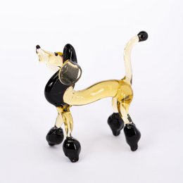 Glass poodle statue in a stylized, abstract design with a golden color and black accents. The poodle has a distinctive poodle-like shape with a curled tail and legs.