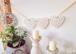 Vintage-style heart garland with intricate lace-like pattern, perfect for home decor or wedding accents.