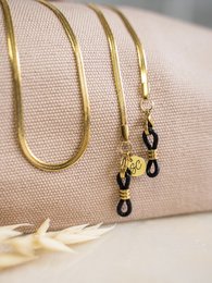 Gold-toned sunglasses cord with black accents. Stylish accessory to keep sunglasses secure.