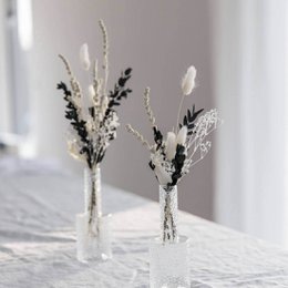 Dried flower bouquet with dark eucalyptus, featuring a mix of white and black floral elements in a minimalist, natural arrangement.