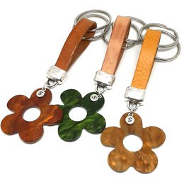 Flower Power leather keychain in olive green, topaz cognac, and golden brown colors. Featuring leather flower-shaped charms in various shades.