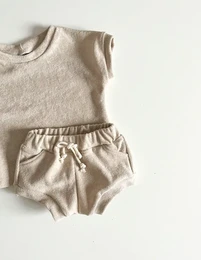 Beige terry cloth kids oversized t-shirt and shorts set. The t-shirt has a relaxed, comfortable fit and the shorts have an elastic waistband for easy dressing. This casual outfit is perfect for everyday wear.