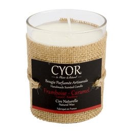 A round, tall natural candle with a raspberry-caramel scent, presented in a burlap-wrapped glass container.